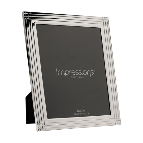 Rectangular silver-plated metal photo frame with grooved stripe border and grid corners, holding a 10 x 8in portrait print, shown on a plain white background.