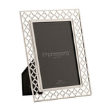 Rectangular photo frame with an openwork lattice border in silver-plated metal, holding a 6 x 4in portrait photo, shown at an angle on a plain white background.