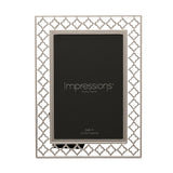 Rectangular silver-plated photo frame with an openwork lattice border of linked four-petal shapes, holding a 4x6in portrait print on a plain white background.