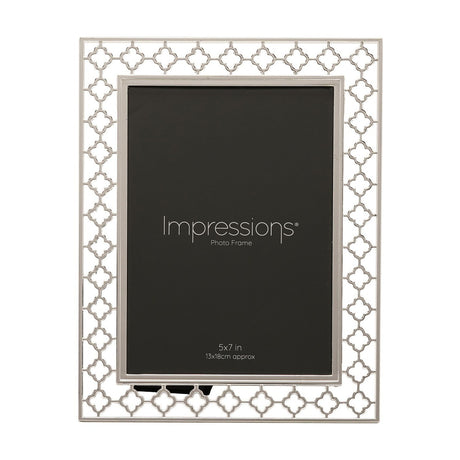 Rectangular photo frame in bright silver-plated metal with a cut-out lattice border of linked four-petal shapes, holding a 5x7in print, shown on a white background.