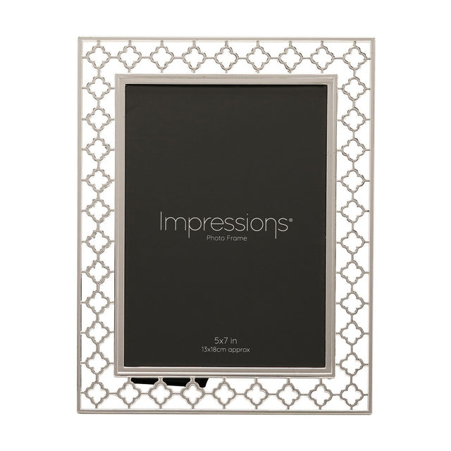 Rectangular photo frame in bright silver-plated metal with a cut-out lattice border of linked four-petal shapes, holding a 5x7in print, shown on a white background.