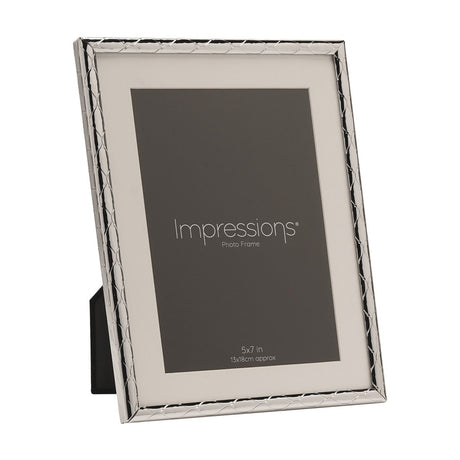 Silver metal photo frame with a criss cross lattice pattern border and white mount, holding a 5x7in placeholder image, shown at an angle on a plain white background.