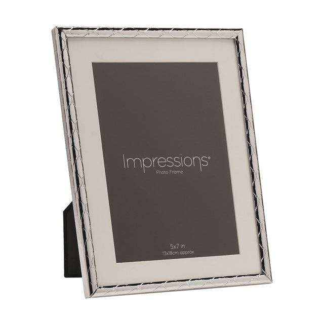 Silver metal photo frame with a criss cross lattice pattern border and white mount, holding a 5x7in placeholder image, shown at an angle on a plain white background.