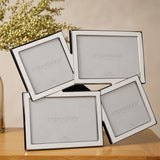 Overlapping multi-aperture photo frame in shiny silver metal, with four tilted openings—two square, two landscape—displayed on a wooden surface.