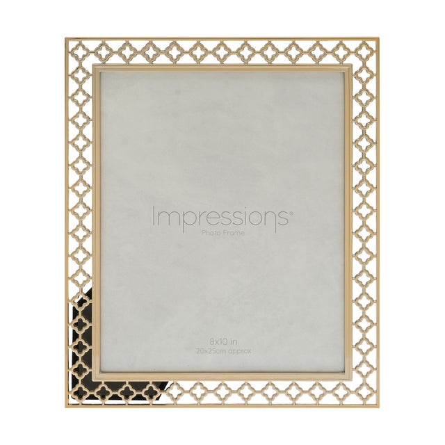 Gold freestanding metal photo frame with a cut-out lattice quatrefoil border and plain outer rim, holding a 10 x 8in print, shown on a white background.