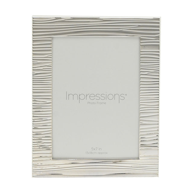 Rectangular silver-plated photo frame with a rippling, ridged texture across the border, holding a 7 x 5in print, shown on a plain white background.