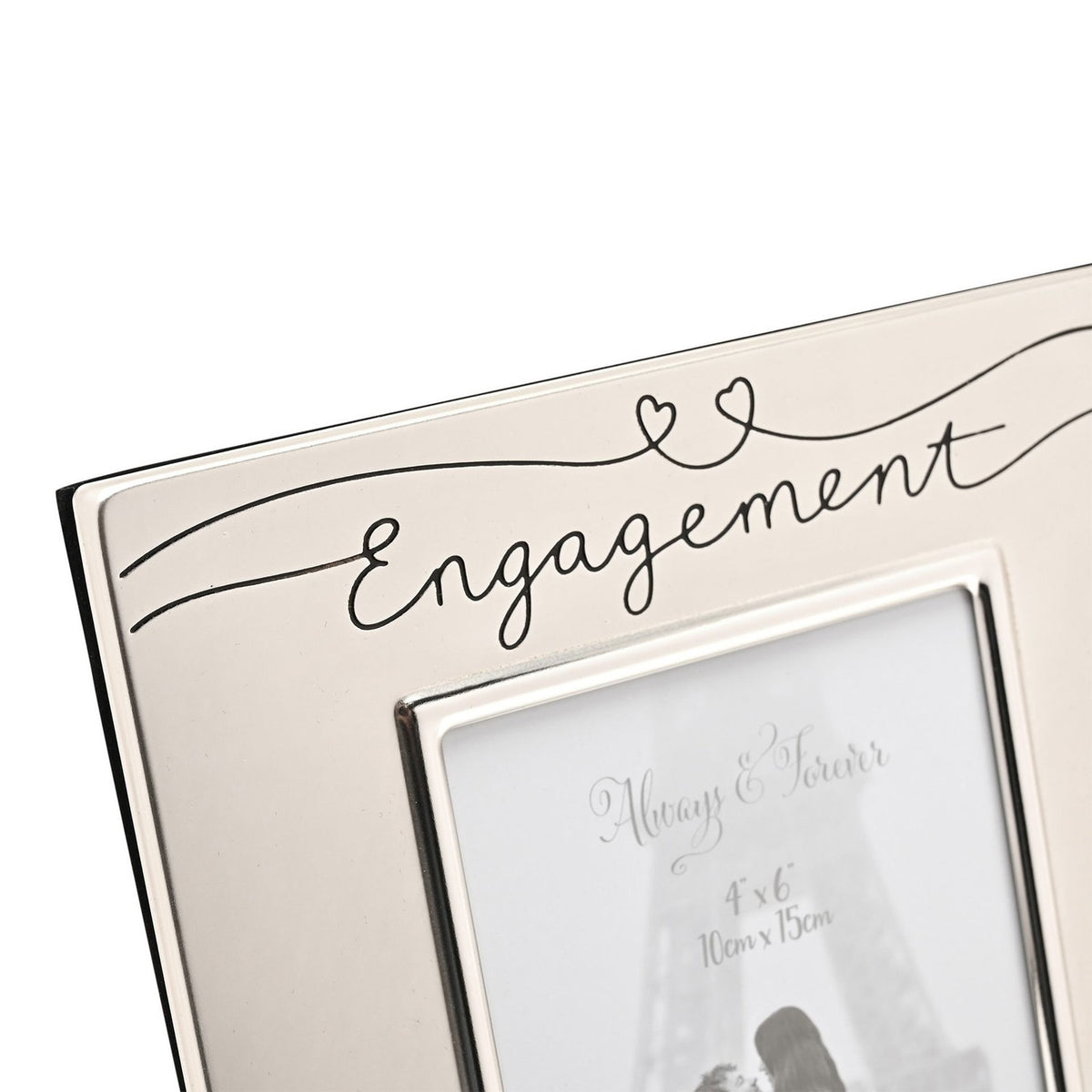 Close-up of a satin silverplated Engagement photo frame for a 6 x 4in photo, with "Engagement" in black script and a heart-topped line across the metal frame's top edge.