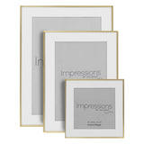 Three brushed brass finish photo frames with white mounts in graduated sizes, rectangular and square shapes, shown against a plain white background.