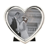 Heart-shaped silverplated alloy photo frame with beaded edge, holding a 4 x 4in square photo, standing on a black easel against a white background.