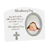 White arched Christening Day photo frame with oval 3x4in silver photo opening, printed blessing verse, and a small silver cross with heart detail below.
