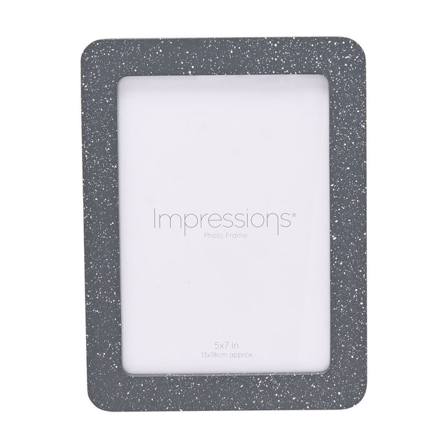 Speckled rounded wooden photo frame in grey with white flecks, holding a 7 x 5in print, shown on a plain white background.