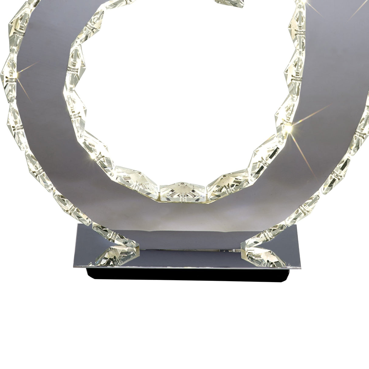 The Galaxy LED Crystal D Shape Table Lamp 12W 4000K in Polished Chrome features a contemporary circular frame with faceted edges, emitting bright white light—ideal for modern ambient lighting.