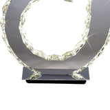 The Galaxy LED Crystal D Shape Table Lamp 12W 4000K in Polished Chrome features a contemporary circular frame with faceted edges, emitting bright white light—ideal for modern ambient lighting.