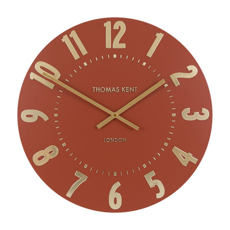 Mulvorne Wall Clock by Thomas Kent in Auburn with a matt terracotta dial, raised gold-tone Arabic numerals and slim baton hands.