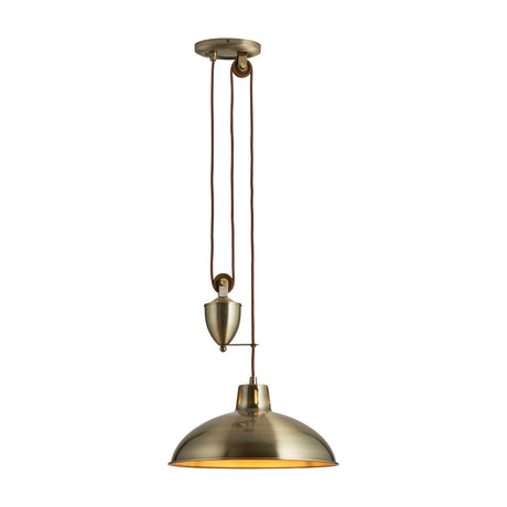 Gallery Direct Perlenna Rise and Fall Pendant Light in antique brass, with domed steel shade, pulley counterweight and braided brown flex on a white background.