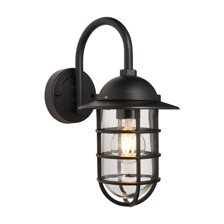 Gallery Direct Porvane nautical wall light in matte black with gooseneck arm, domed hood and caged clear glass shade lit by a warm bulb.