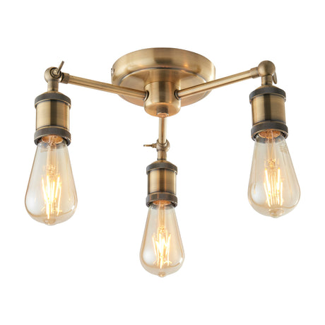 Gallery Direct Halvane Industrial 3-light semi-flush ceiling light in antique brass with adjustable arms and exposed E27 teardrop filament bulbs.