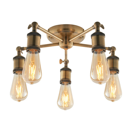 Gallery Direct Halvane Industrial 5 Light Semi-Flush Ceiling Light in antique brass with exposed filament bulbs on radiating arms, plain background.