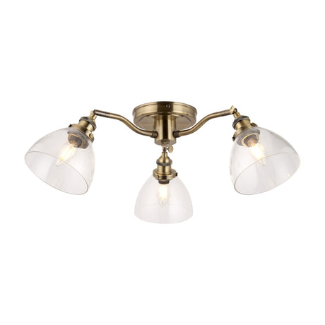 Gallery Direct Sarwen 3 light semi-flush ceiling light in antique brass with three clear glass dome shades on curved adjustable arms.