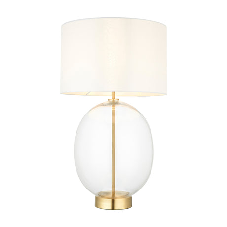 Gallery Direct Weslenna table lamp with clear oval glass body, satin brass stem and base, and vintage white fabric drum shade on a white background.