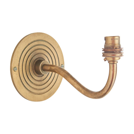 Gallery Direct Rivenne Curve Wall Light in antique brass with a ringed circular backplate, gooseneck arm and exposed B22 bulb holder.