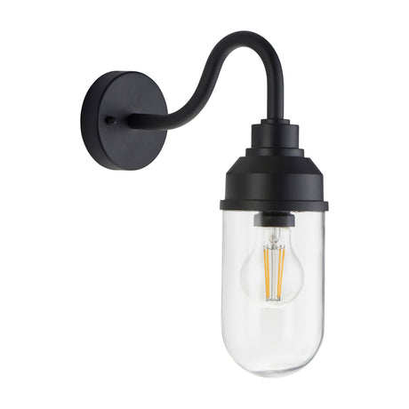 Gallery Direct Truvael Wall Light in textured black with a curved gooseneck arm, circular backplate and clear cylindrical glass shade housing a filament bulb.