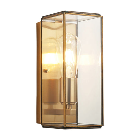 Vendaris boxed glass wall light by Gallery Direct in antique brass, with clear glass panels framing a single exposed Edison-style filament bulb.