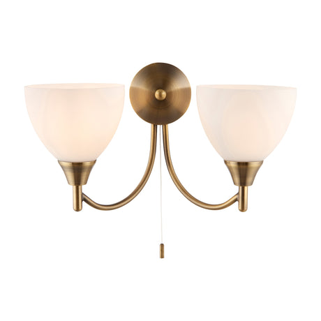 Gallery Direct Silvenna Twin Wall Light with antique brass curved arms, two opal glass bell shades, round backplate and pull cord switch.