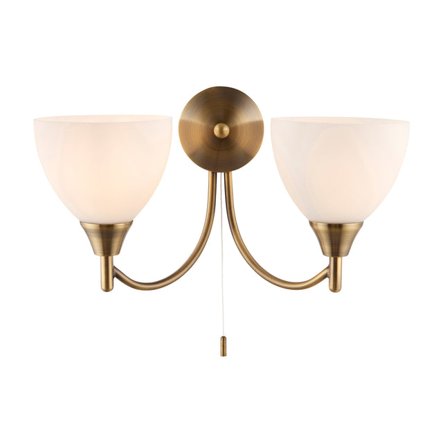 Gallery Direct Silvenna Twin Wall Light with antique brass curved arms, two opal glass bell shades, round backplate and pull cord switch.