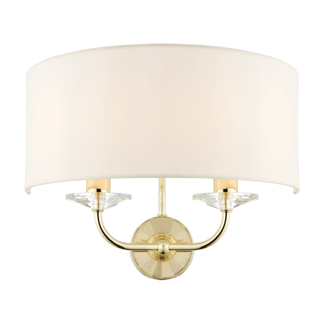 Gallery Direct Ostwyn 2 light wall fitting with vintage white half-drum fabric shade, brass curved arms and clear crystal accents on a round backplate.