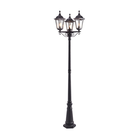 Gallery Direct Burvael 3-light outdoor lamp post in matt black with hexagonal glass lanterns on scrolled arms and a fluted column.