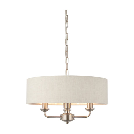 Gallery Direct Clervorne 3 light pendant with natural linen-effect fabric drum shade, brushed chrome arms and chain suspension, on a white background.