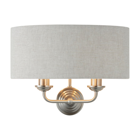 Gallery Direct Clervorne 2 Light Wall Light with brushed nickel and brass frame, twin candle arms and a natural half-drum fabric shade.