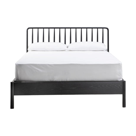 Gallery Direct Wycvorne Spindle Bed in black with turned metal spindle headboard, low wood footboard, and white bedding on a plain background.