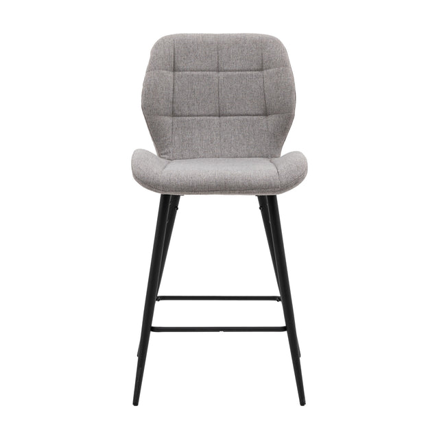 Gallery Direct Manvorne light grey upholstered bar stool with square-quilted padded back and seat on black tapered metal legs with footrest.