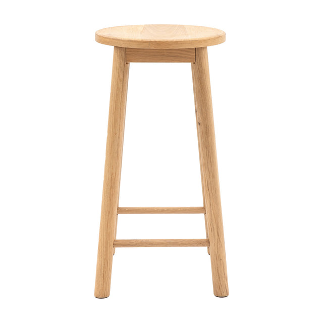Gallery Direct Hatvenne Backless Bar Stool in natural oak with a round dished seat, four tapered legs and two stretcher bars, on a white background.