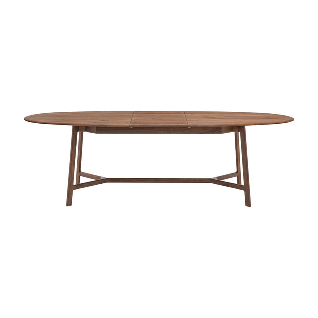 Gallery Direct Madrelle Extending Dining Table in walnut-toned solid oak with oval top, tapered splayed legs and low cross stretcher, on a white background.