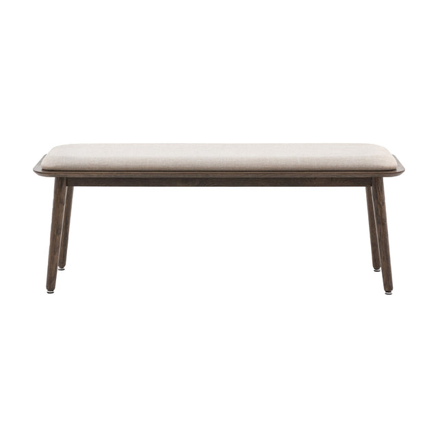 Gallery Direct Hatvenne Upholstered Dining Bench with neutral fabric seat cushion and tapered smoked oak legs on a white background.