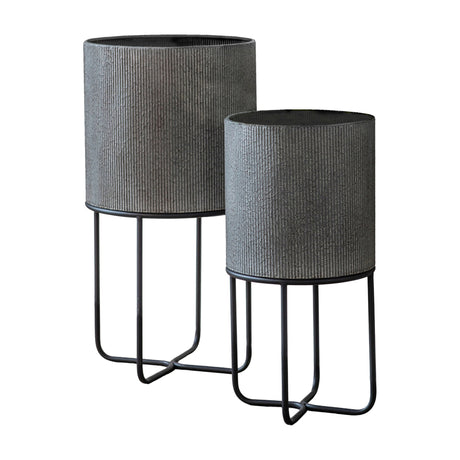 Gallery Direct Edvelle set of two ribbed grey metal cylindrical planters on slim black iron four-leg wire stands, taller and shorter pair on white.