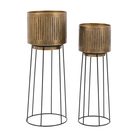 Gallery Direct Elvorne set of two antique brass ribbed planters on tall black iron wire stands in two heights, on a white background.