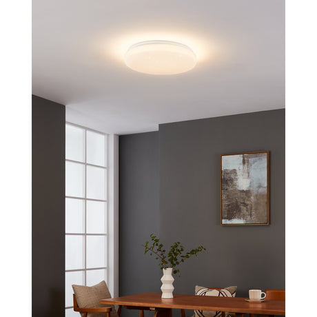Galmane Smart Crystal Effect LED Flush Ceiling Light 38cm IP44 in white, illuminating a dining area with a dark grey wall, framed artwork, wooden table and vase.