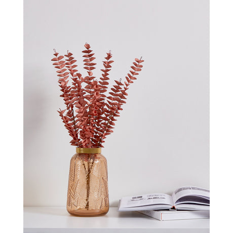 Gannan Artificial Leaf Spray with terracotta pink eucalyptus-style stems and curled tendril tips, displayed in an amber glass vase on a shelf beside books.