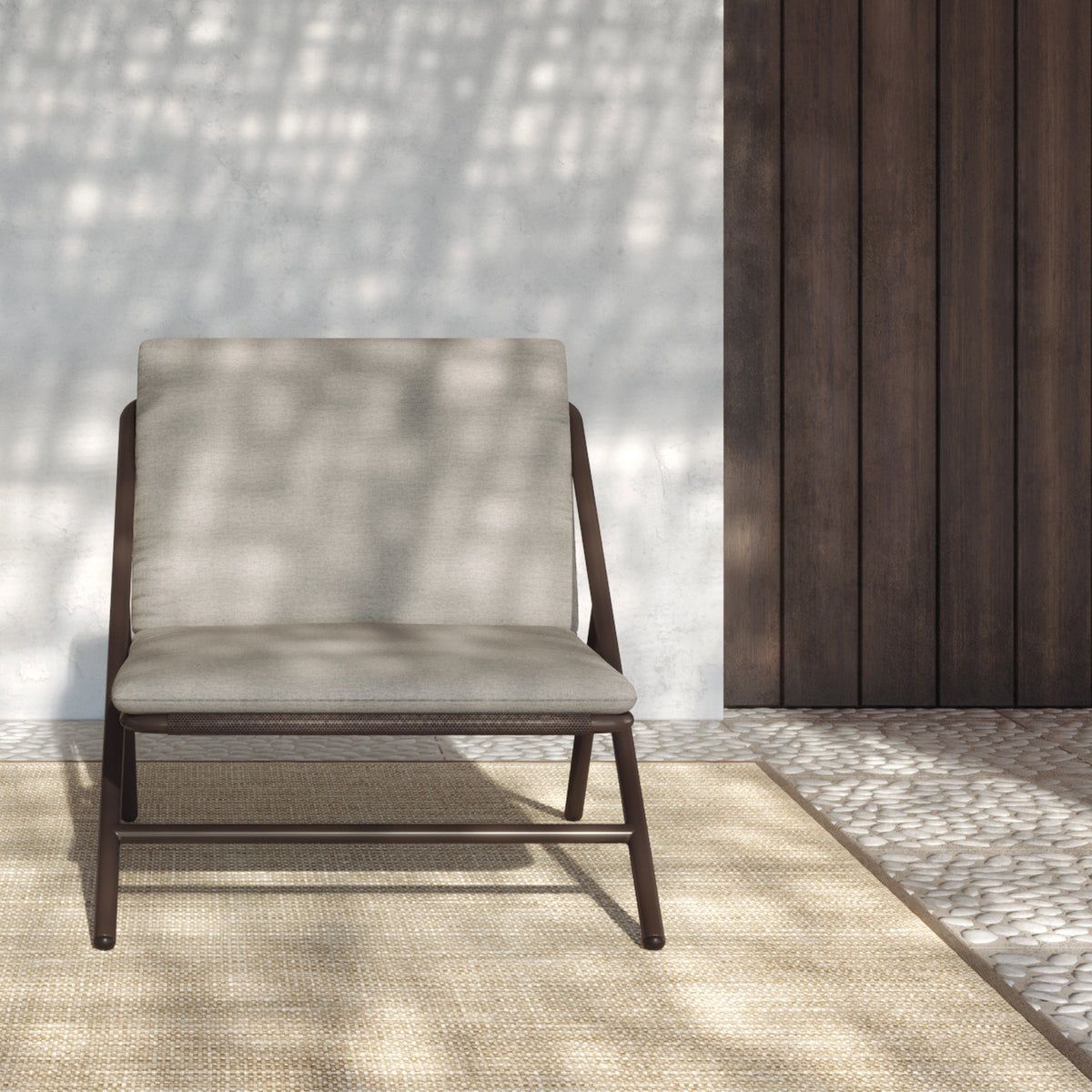 Garda High Back Garden Armchair Cushion Set in beige fabric shown fitted to a dark brown aluminium frame chair, set against a stone wall and wood panel backdrop.