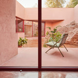 Garda High Back Garden Armchair Cushion Set in sage green fabric fitted to an aluminium folding frame chair on a pink-toned outdoor patio.