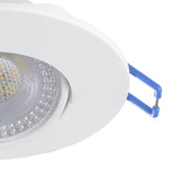Close-up of the Gedrez round LED downlight in white, showing the white plastic bezel, clear lens over integrated LEDs, and blue spring clip fitting, on a plain white background.