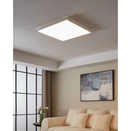 Gevette Smart LED Panel Light, 59.5 x 59.5cm square white ceiling fixture with slim frame, shown illuminated on a living room ceiling above a cream sofa.