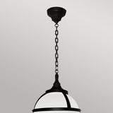 The Glenbeigh 1 Light Outdoor Chain Pendant in black, crafted from corrosion-proof black polymer and featuring a frosted glass dome, hangs elegantly from a chain against an off-white wall.