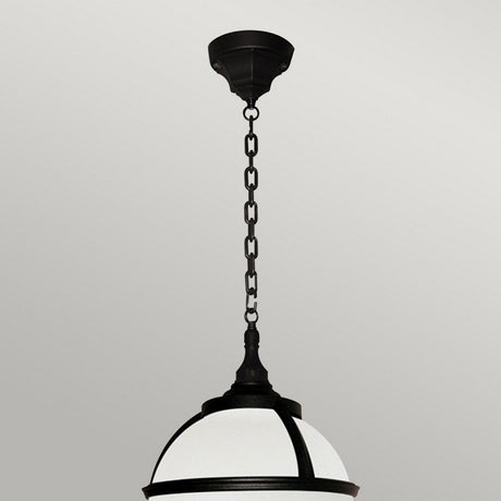 The Glenbeigh 1 Light Outdoor Chain Pendant in black, crafted from corrosion-proof black polymer and featuring a frosted glass dome, hangs elegantly from a chain against an off-white wall.