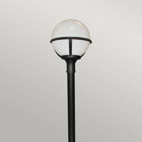 The Glenbeigh 1 Light Pillar Lantern in black, featuring a round, white globe-shaped light fixture, stands against a plain, light gray background, showcasing elegant outdoor lighting. With its IP44 rating and corrosion-proof design, this lantern ensures both style and durability in any setting.
