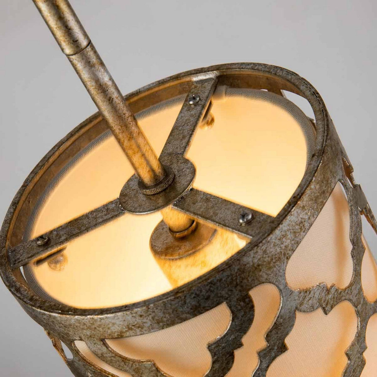 Close-up of the Arabella 1 Light Duo-Mount Mini Pendant/Semi-Flush in a cylindrical design, showcasing an ornate gold frame with an ivory fabric shade. The light emits a soft glow, creating an ambient effect against a plain background. Its duo-mounting option provides versatility for any setting.